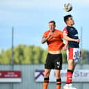 Dundee United defender Kevin Holt wins this header against Falkirk's Ross MacIver.