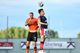 Dundee United defender Kevin Holt wins this header against Falkirk's Ross MacIver.