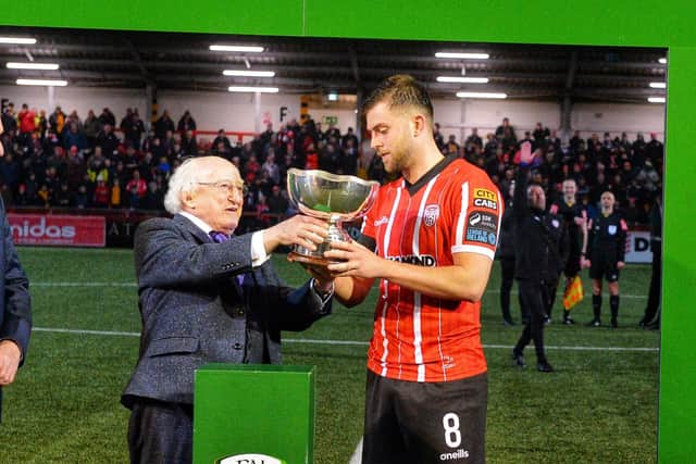 President Michael D. Higgins presents Derry City's Will Patching with the President's Cup at the Ryan McBride Brandywell Stadium.