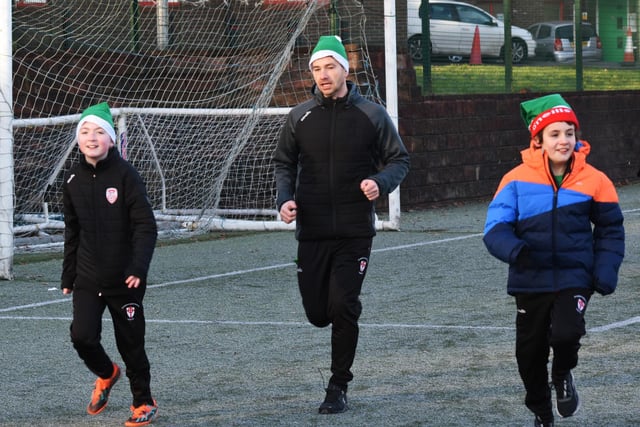 Benjamin, Mr Quigley and Luka taking part in the Manchester United Foundation's Santa's Run at Magee College on Tuesday morning.