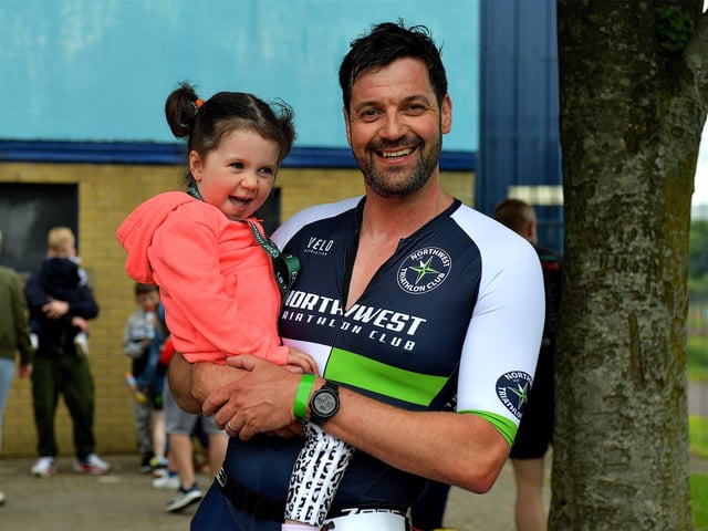 David McGonigle is congratulated by his daughter after completing the Liam Ball Triathlon on Sunday morning.
