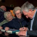 Denis Bradley signs copies of his book ‘Peace Comes Dropping Slowly’, at the official launch in St Columb’s Hall on Thursday evening last. Photo: George Sweeney