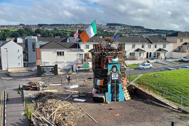 The 11th night bonfire in the Fountain festooned with national emblems and a Celtic and Palestinian flag.