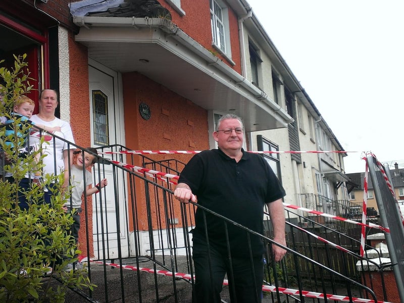 Moyola Drive resident Ann Lynch pictured with her children next door to a house where an outside roof was deemed unsafe. Included in the photo is local Sinn Féin councillor, Tony Hassan.