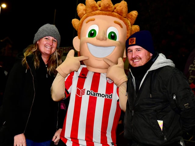The Candy Stripe Kid poses for a photo with these happy Derry City fans.
