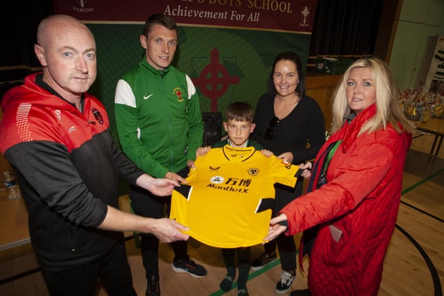 Winners of the Lee Harkin jersey (currently signed by Premiership club Wolverhampton Wanderers) at the Sean O’Kane Memorial Cup on Sunday was Foyle Harps Jack Strunks. Included are Christy McGeehan, organiser, Emmett McGinty, teacher/organiser, Ciara McGlynn and Mrs. Ciara Deane, principal, St. Joseph’s Boys School.