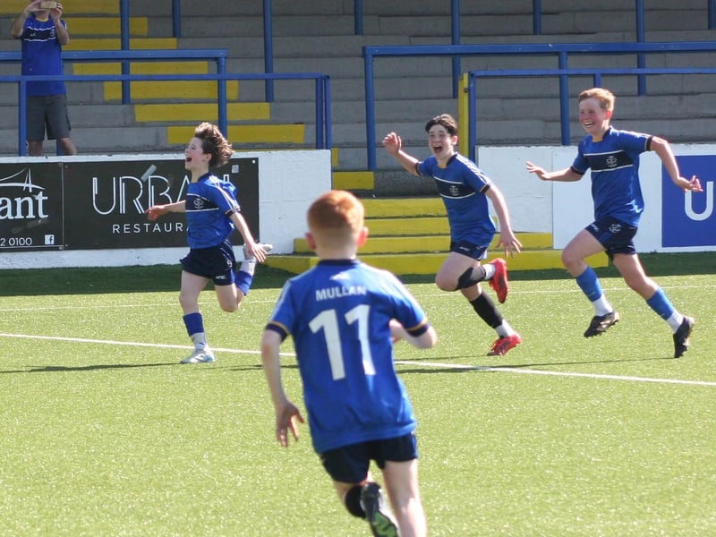 St Columb's College players wheel away in celebration after scoring a third against Lisneal in the final.