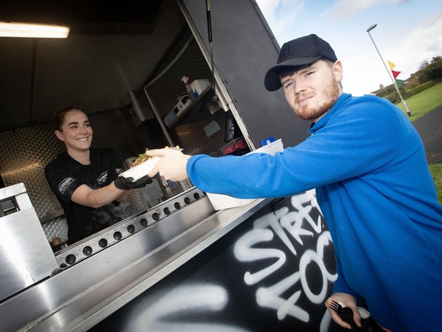 SERVICE WITH A SMILE!. . . .Sampling some of the excellent food served up during Saturday's Waterside Together Festival. : .