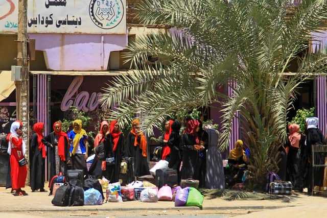 People wait for a bus to flee from southern Khartoum on April 18, 2023 as fighting between the army and paramilitary forces led by rival generals rages for a fourth day, despite growing international calls for an end to hostilities. (Photo by AFP) (Photo by -/AFP via Getty Images)