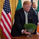 2019: US President Donald Trump holds a bowl of shamrocks presented to him in Washington, DC, March 14, 2019. (Photo by SAUL LOEB /AFP via Getty Images)