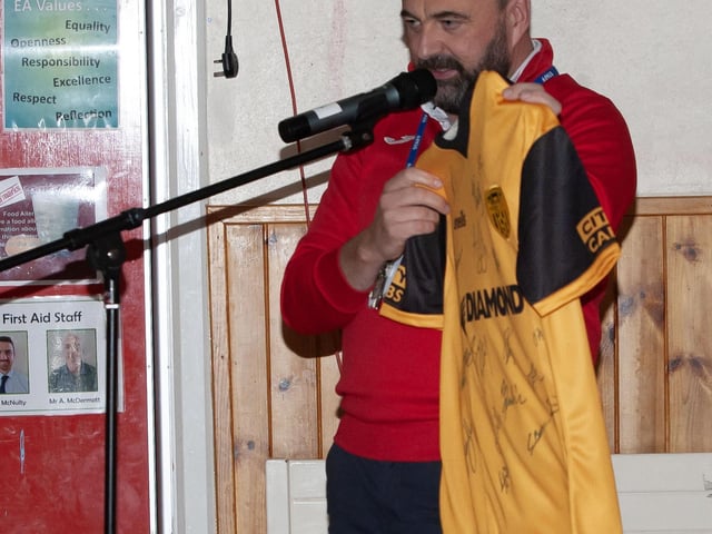 Mr. Feargal Friel showing off the jersey donated by the three Derry City players on Tuesday.