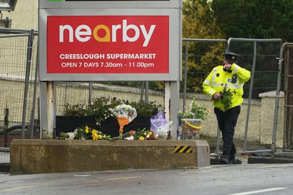 A member of An Garda brings flowers to the scene of the explosion at the Applegreen service station in the village of Creeslough in Co Donegal, where ten people were killed.