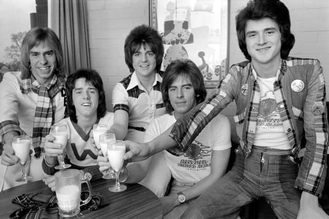 Bay City Rollers toast their success with milk. Pictured are Derek Longmuir Stuart Wood Eric Faulkner Allan Longmuir Leslie Mckeown. March, 1975