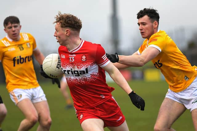 Derry’s Niall O’Donnell slips a tackle from Cahir Donnelly of Antrim. Photo: George Sweeney