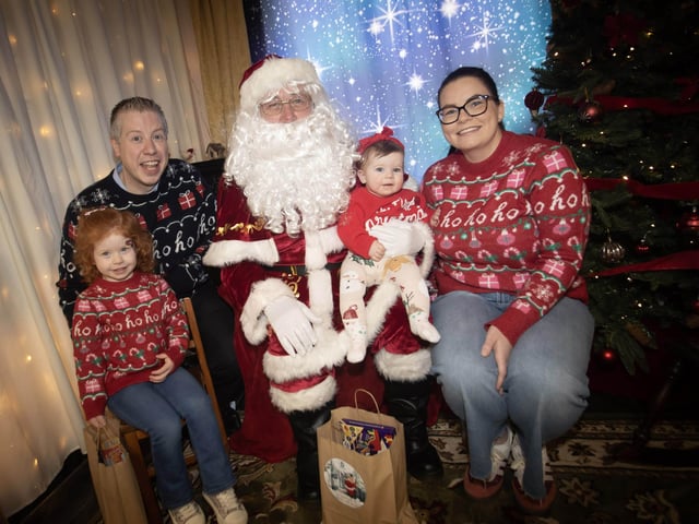 One of the many families getting a photo and collecting a present from Santa on Saturday at Derry Credit Union. : .