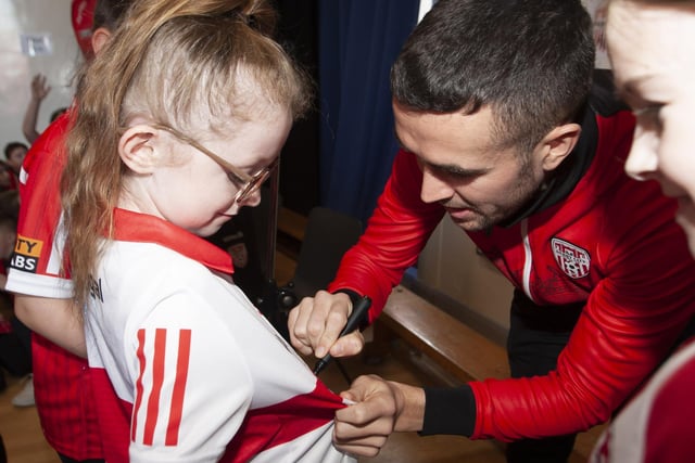 Derry City's Michael Duffy signs one young fan's shirt during Tuesday's visit. (Photo: Jim McCafferty)
