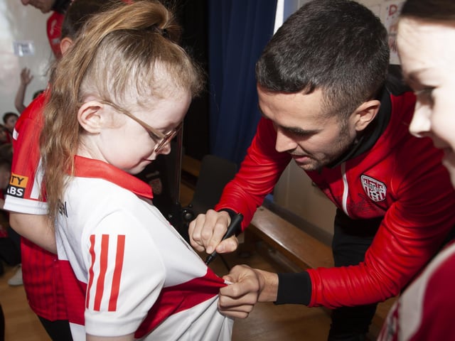 Derry City's Michael Duffy signs one young fan's shirt during Tuesday's visit. (Photo: Jim McCafferty)