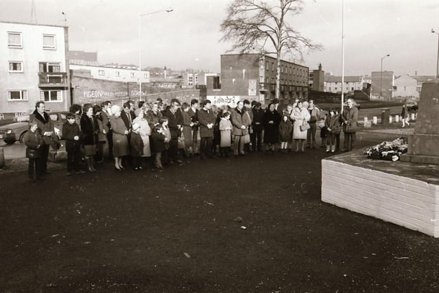 Families gather at the Bloody Sunday monument in Rossville Street on the 12th anniversary of the massacre in 1984.