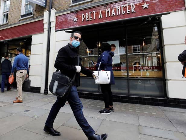 A man wearing PPE (personal protective equipment) passes customers queuing to enter a recently re-opened Pret-A-Manger shop which had originally closed-down due to the COVID-19 pandemic in London (Photo: TOLGA AKMEN/AFP via Getty Images)