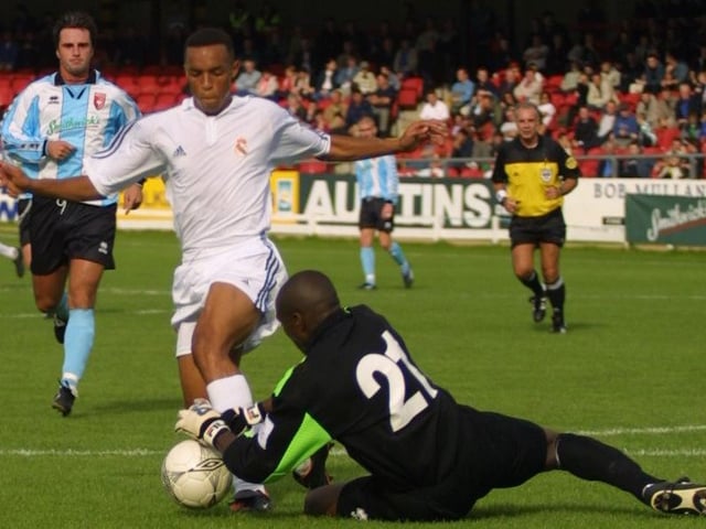 Derry keeper Russell Payne dives to the feet of a rushing Real Madrid forward.(2208JB84)