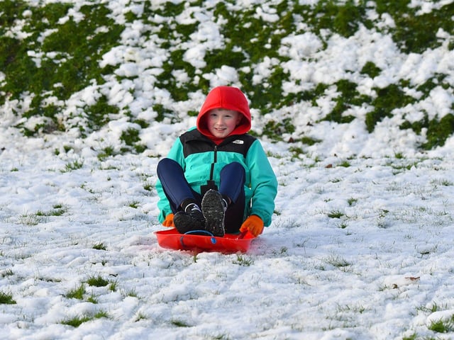 Children enjoy a day off school and a slide in the snow in Brooke Park on Thursday afternoon. Photo: George Sweeney