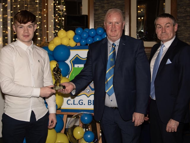 Darren Bradley, Senior Football Young Player of the Year 2024, receives his trophy from Liam Gallagher, Club Chair. On right is Mr. Ciaran McLaughlin, former Ulster President, GAA.