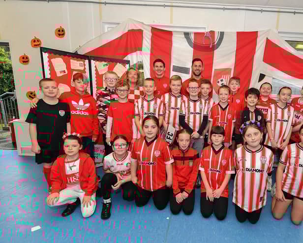 Pupils from Gaelscoil Eadain Mhoir pictured with Derry City’s Ciaran Coll and Pat Hoban during their visit to the school on Monday morning. Photo: George Sweeney