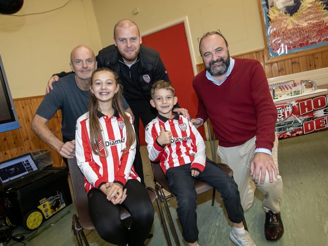 Derry manager Mark Connolly pictured with his children - Ora and Rohan, Mr Andy McDermott, school caretaker and principal Mr. Feargal Friel on Friday. (Photos: Jim McCafferty Photography)