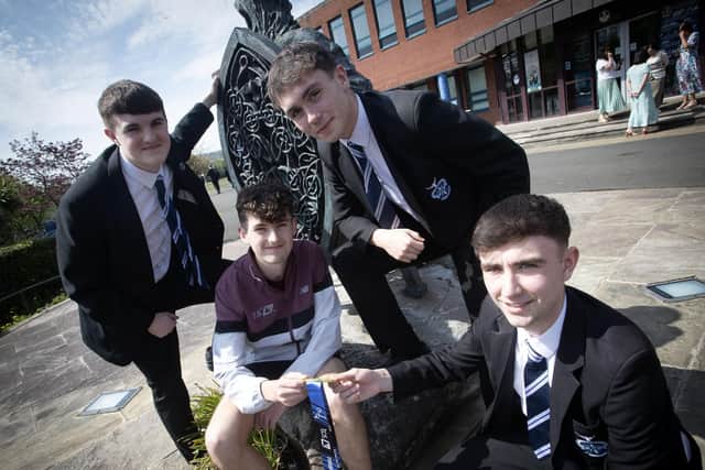 A very proud Sam showing off his medals to some of the senior students during Monday's visit. From left, Malachy Coyle. Somhairle McFadden and Tiernan Doherty. (Photo: Jim McCafferty)