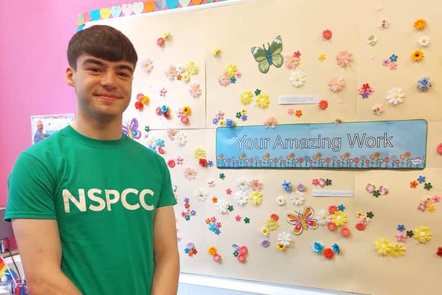 YPBC member Markus Smith at the Childline Foyle base. Each flower on the wallboard represents a young person who has contacted Childline
