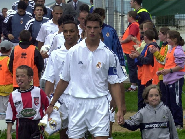 Francisco Pavon leads the Real Madrid team onto the pitch.