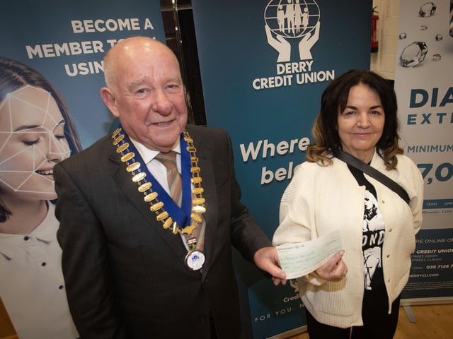 Derry Credit Union president Colm McCauley presenting the £500 prize to Charmaine Leonard at Monday night's AGM. : .