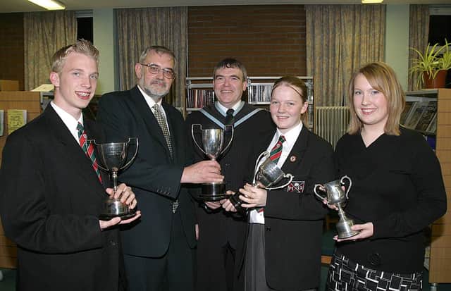 Rev. Bert Tosh, guest speaker at Clondermot High Schools annual Prize-Giving, presents awards to (from left)  Darran Dougherty, Business Studies cup, Lisa Holmes, cup for Mathematics and Jody Hawthorne, cup for Art and Design.  Included is David Funston, vice-principal. (2810T07).:Derry and Donegal secondary school pupils in October 2003