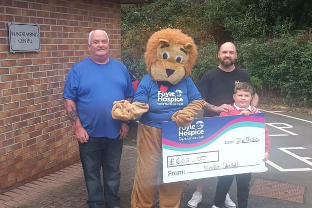 Noah Campbell, Drumahoe PS Pupil, Aged 7, pictured with his daddy Mark and Granda David presenting Hospice Harry with a cheque for £602.00. Noah walked 30 miles in 30 days in September.