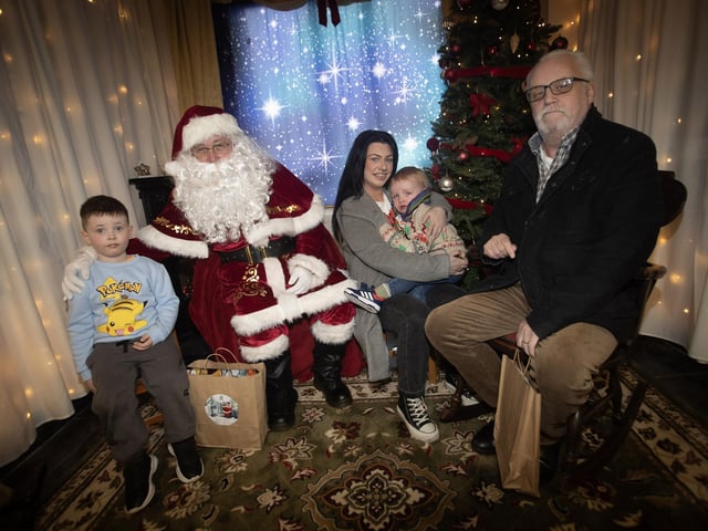 One of the many families getting a photo and collecting a present from Santa on Saturday at Derry Credit Union. : .