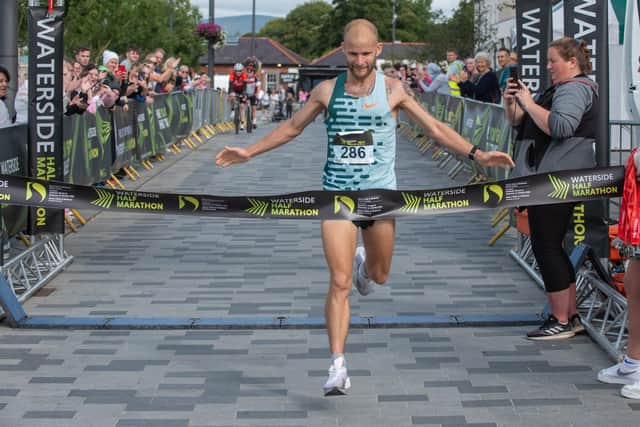 Kyle Doherty begins his celebrations as he claims the 2023 Waterside Half Marathon Men's title on Sunday. Picture Martin McKeown. 03.09.23