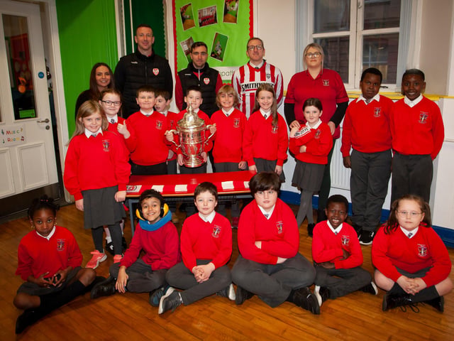 P5 pupils at St. Eugene’s PS show their support for Derry City on Monday last as players Shane McEleney and Joe Thompson brought the FAI Cup to the school.