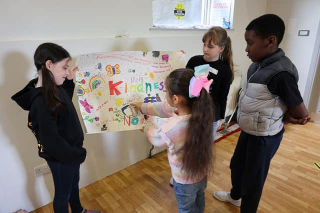 Young people proudly displaying their artwork during Summer Club 2023, created under the instruction of local creative Estefanía Baena.