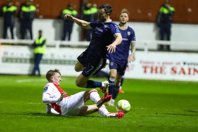 Chris Forrester goes in strongly against Michael Duffy at Richmond Park on Monday night. Photo by Kevin Moore.