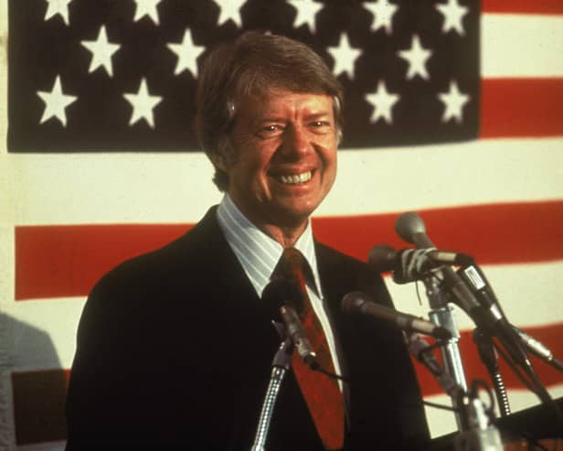 U.S. president Jimmy Carter smiling at a podium in front of an American flag, 1970s. (Photo by Hulton Archive/Getty Images)
