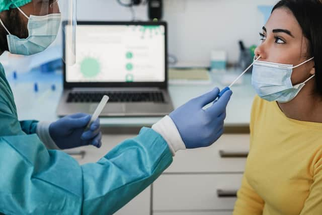 Doctor making swab nasal test to young woman in medical clinic for possible coronavirus infection. (File picture/ Adobe)