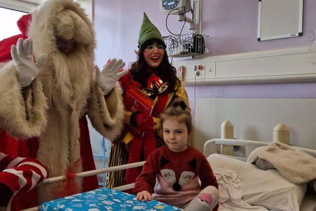 Charli McCafferty (4) with Santa and his elves.