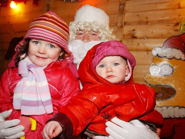Niamh and Aoife McDermott get a hug from Santa. (0612PG64)                                : Christmas in Inishowen in 2005.