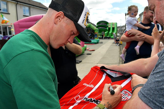 James McClean signs a football shirt, for a fan, during a street party held in Creggan Heights, on Saturday afternoon, to celebrate James winning his 100th international cap for the Republic of Ireland. Photo: George Sweeney. DER2325GS - 105
