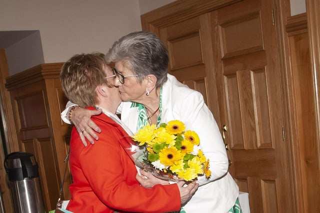 Ursula is presented with a bouquet of flowers from a member of the Casey family at Tuesday’s reception in Derry’s Guildhall. She looked after the family’s late mother Eileen.