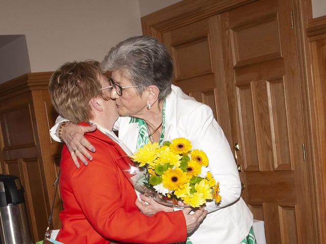 Ursula is presented with a bouquet of flowers from a member of the Casey family at Tuesday’s reception in Derry’s Guildhall. She looked after the family’s late mother Eileen.