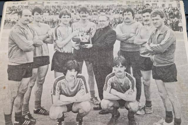 Rev. Kieran O'Doherty, Adm of the new Holy Family Parish, Ballymagroarty, presenting the Bull Park F.A. Open Knock-out Cup to Thomas Healy, captain of Celtic Swifts who defeated Quigley's Points Swifts by 3-2. Also included are members of the winning Swifts team.