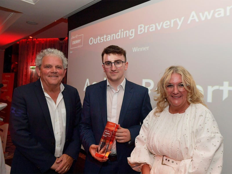Outstanding Bravery Award winner Aodhán Roberts receives his trophy from Shauna Irwin, NW Care Operations Manager, on the right, and compere Adrian Logan. Photo: George Sweeney. DER2325GS – 49