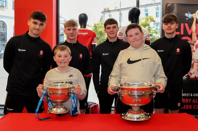 Noah and Luca Doran pictured with members of Derry's All-Ireland Minor Champions team at O'Neill's Superstore last week. Photo: George Sweeney