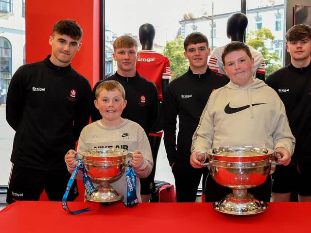 Noah and Luca Doran pictured with members of Derry's All-Ireland Minor Champions team at O'Neill's Superstore last week. Photo: George Sweeney
